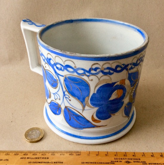 Antique Victorian pottery mug with hand painted decoration with blue flowers and silver resist highlights.