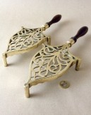 Pair of brass iron stands or kettle trivets with mahogany handles.
