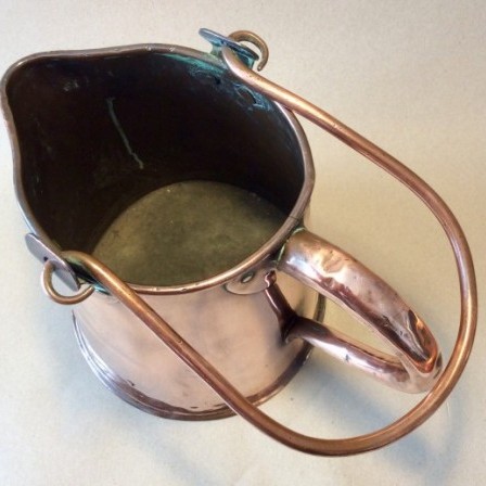 Detail: Antique 19th century copper ale jug with copper bail  carrying handle.