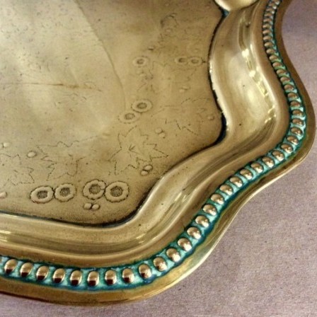 Detail: Victorian pressed brass tray with wavy edge an flower decoration to centre.