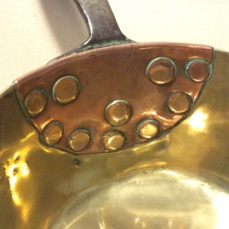 Detail: Antique early early 19th century brass saucepan with old repair to handle.