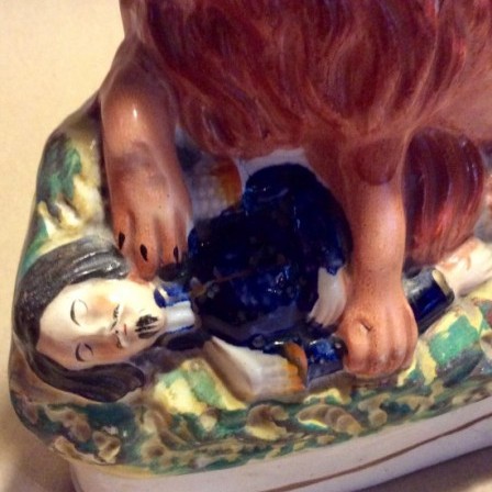 Detail: Antique Staffordshire pottery figure. The British lion crushing Napoleon III.