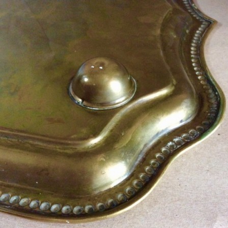 Detail: Victorian pressed brass tray with wavy edge an flower decoration to centre.