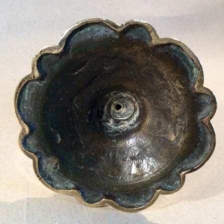 Detail: Single 18th century brass candle stick with petal base